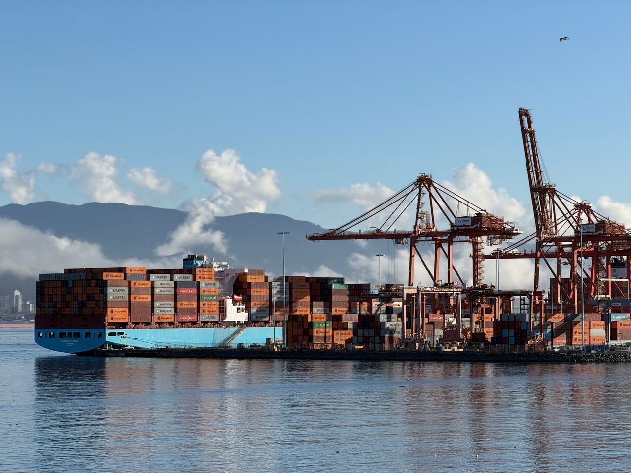 Cargo ship at Vancouver, Canada port with cranes, representing international trade